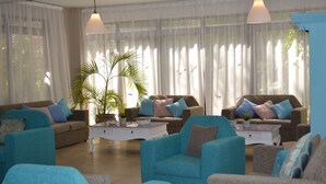 A spacious living room with two sofas, a coffee table, and a potted plant. - Tasiana Star (Limassol)