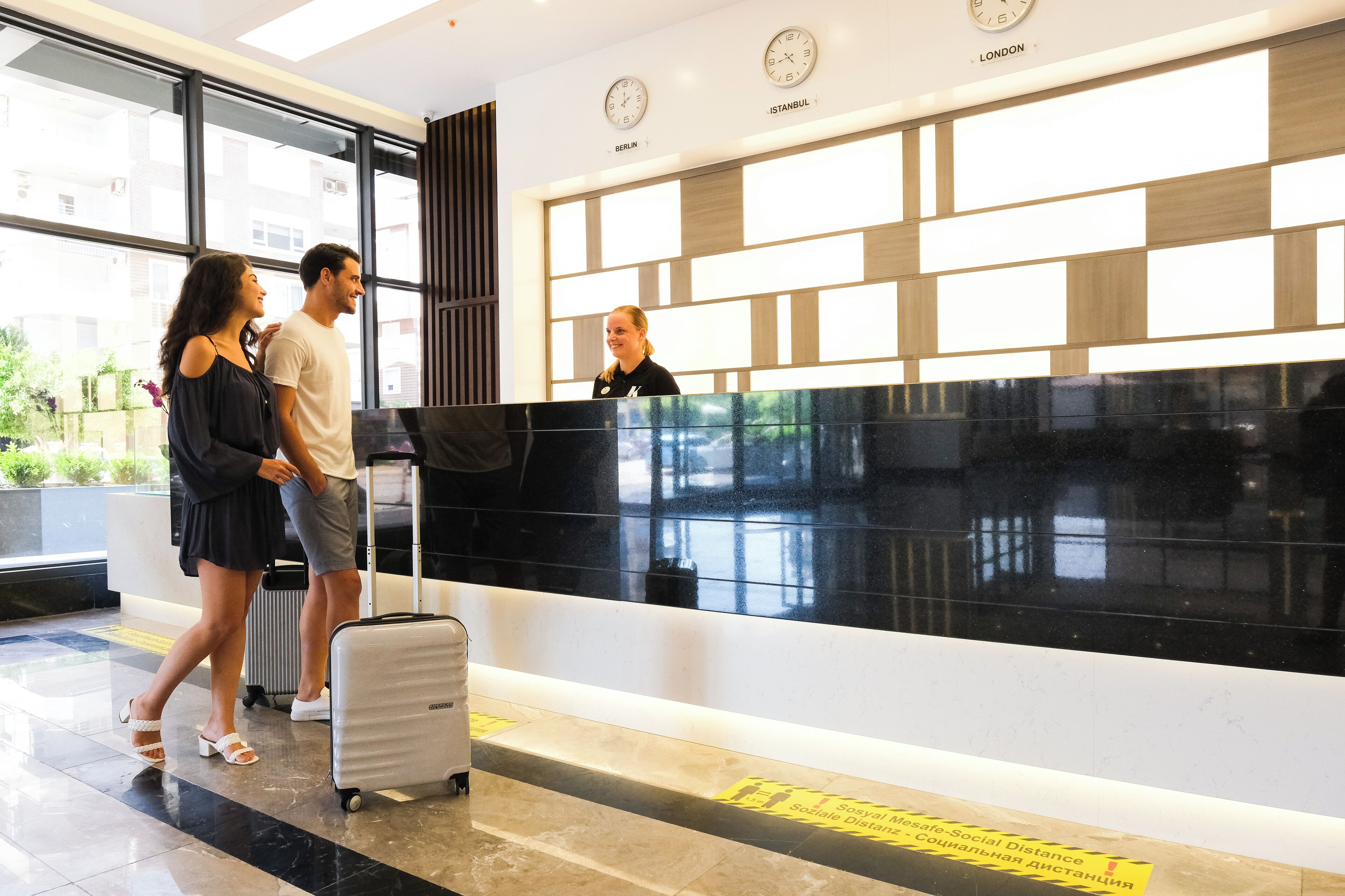 A reception desk with clocks displaying times for Berlin, Istanbul, and London.