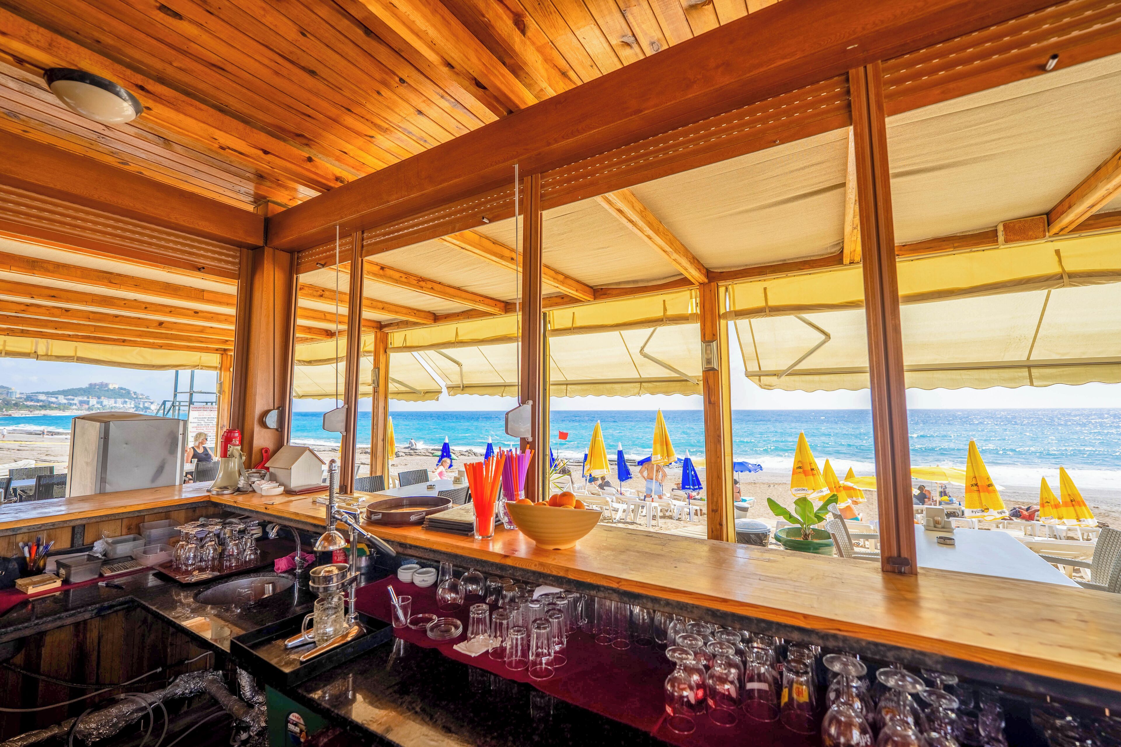 A bar area with a view of the beach and ocean.