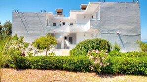 Un bâtiment moderne à deux étages, doté d’un toit plat, d’un balcon au deuxième étage et d’un escalier menant à l’entrée.