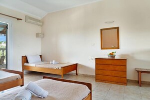 Un dormitorio con una cama individual, un tocador, un espejo y una mesita.