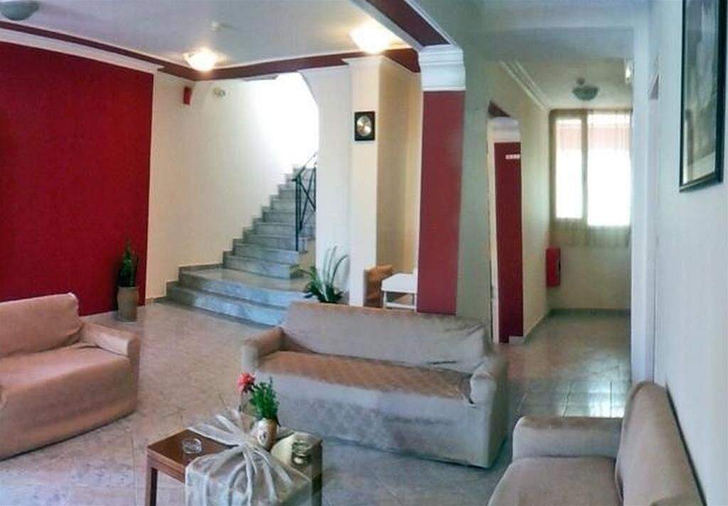 A spacious living area with a staircase, two sofas, and a small table with a plant.