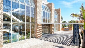 A modern building with large glass windows, stone walls, and a staircase leading to an upper level. - LABRANDA Hotel Golden Beach  (Pajara)