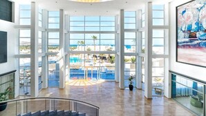 A spacious atrium with large windows offering views of a pool and beach. - LABRANDA Hotel Golden Beach  (Pajara)