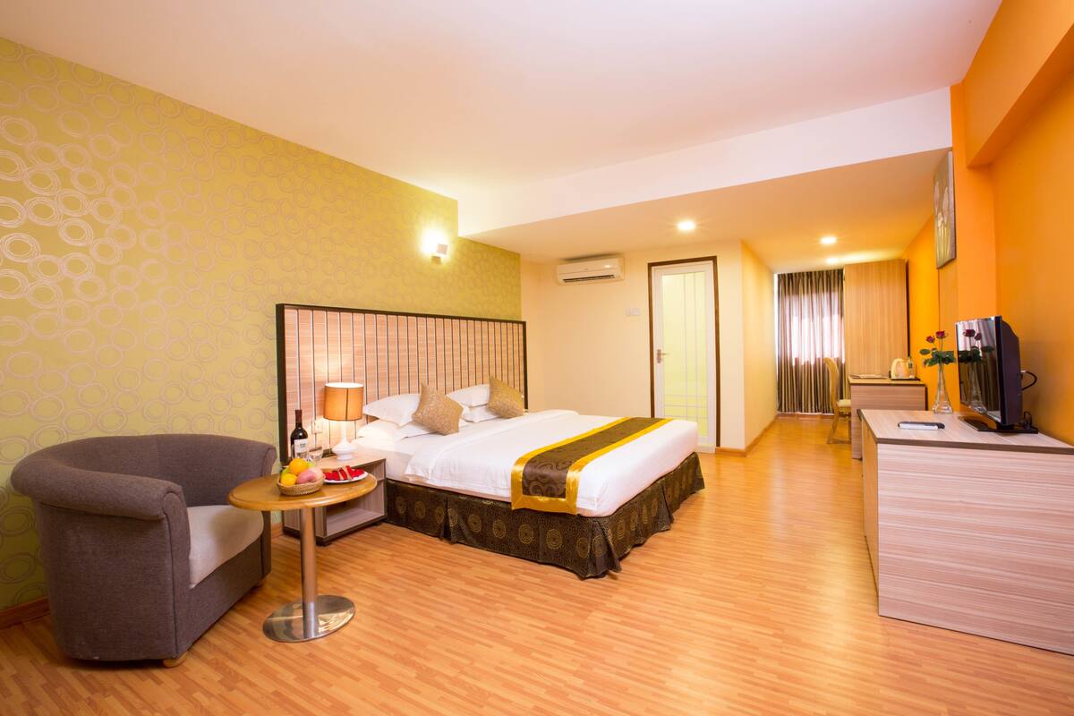 Ein Hotelzimmer mit Bett, Schreibtisch, Stuhl und Fernseher.