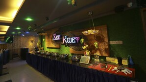 A buffet area with a sign reading "Zee Kwet," featuring a variety of dishes and utensils on a counter. - Uptown Hotel (Yangon)