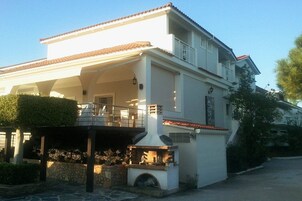 Una casa de dos pisos con un porche cubierto, una chimenea y un garaje.
