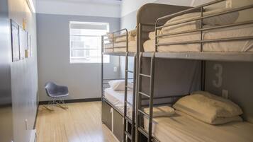 Habitación con literas, una ventana, una silla y una puerta.