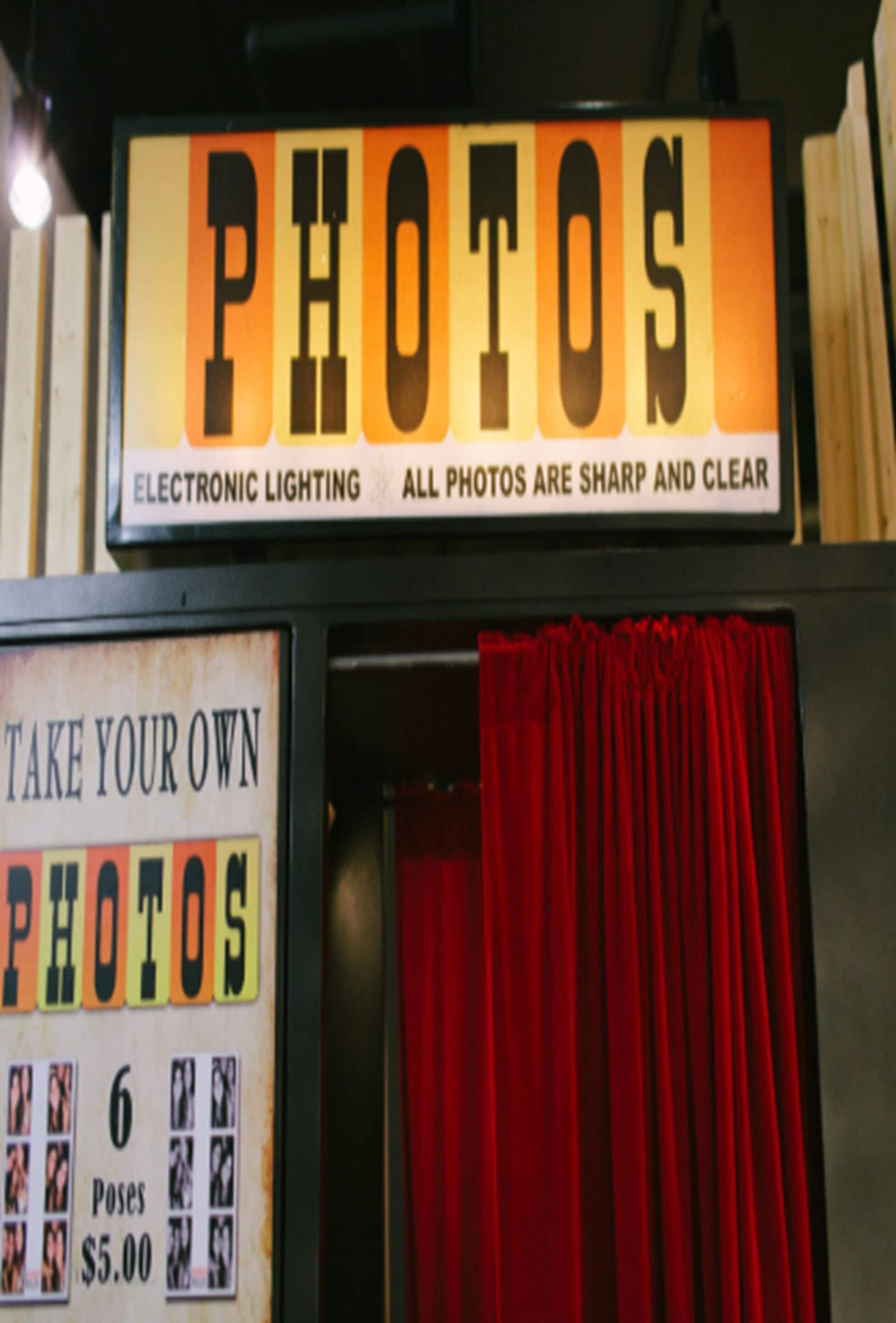 A photo booth with a sign indicating it is for taking your own photos, offering 6 poses for $5.00.