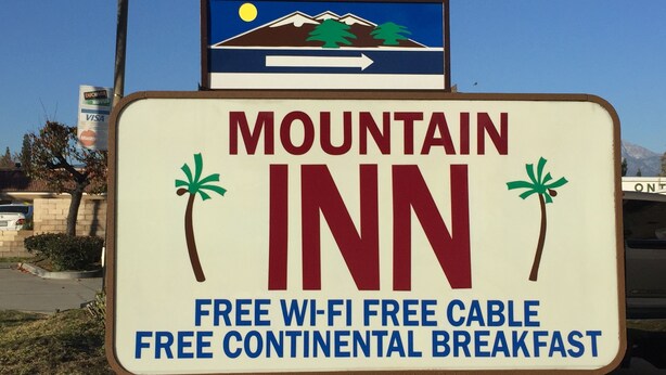 Letrero del Mountain Inn anunciando Wi-Fi gratuito, televisión por cable gratis y desayuno continental sin costo.