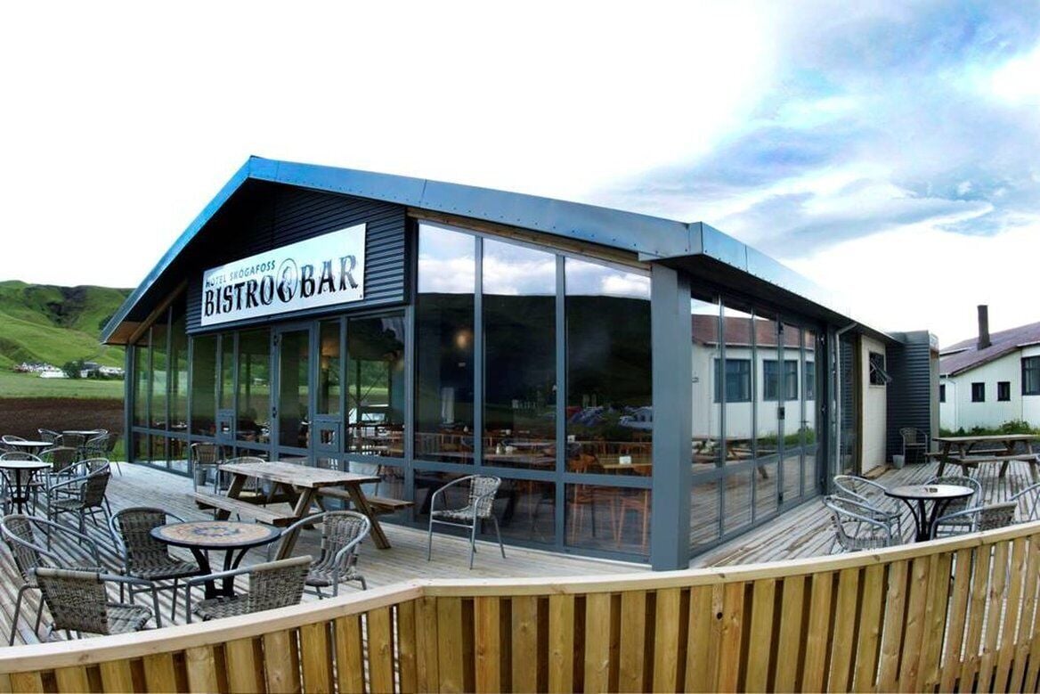 A restaurant with a sign reading 'BISTRO BAR' and a view of the surrounding landscape.