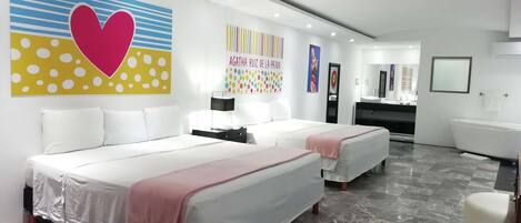 Een moderne hotelkamer met twee bedden, een badkamer en een kaptafel.