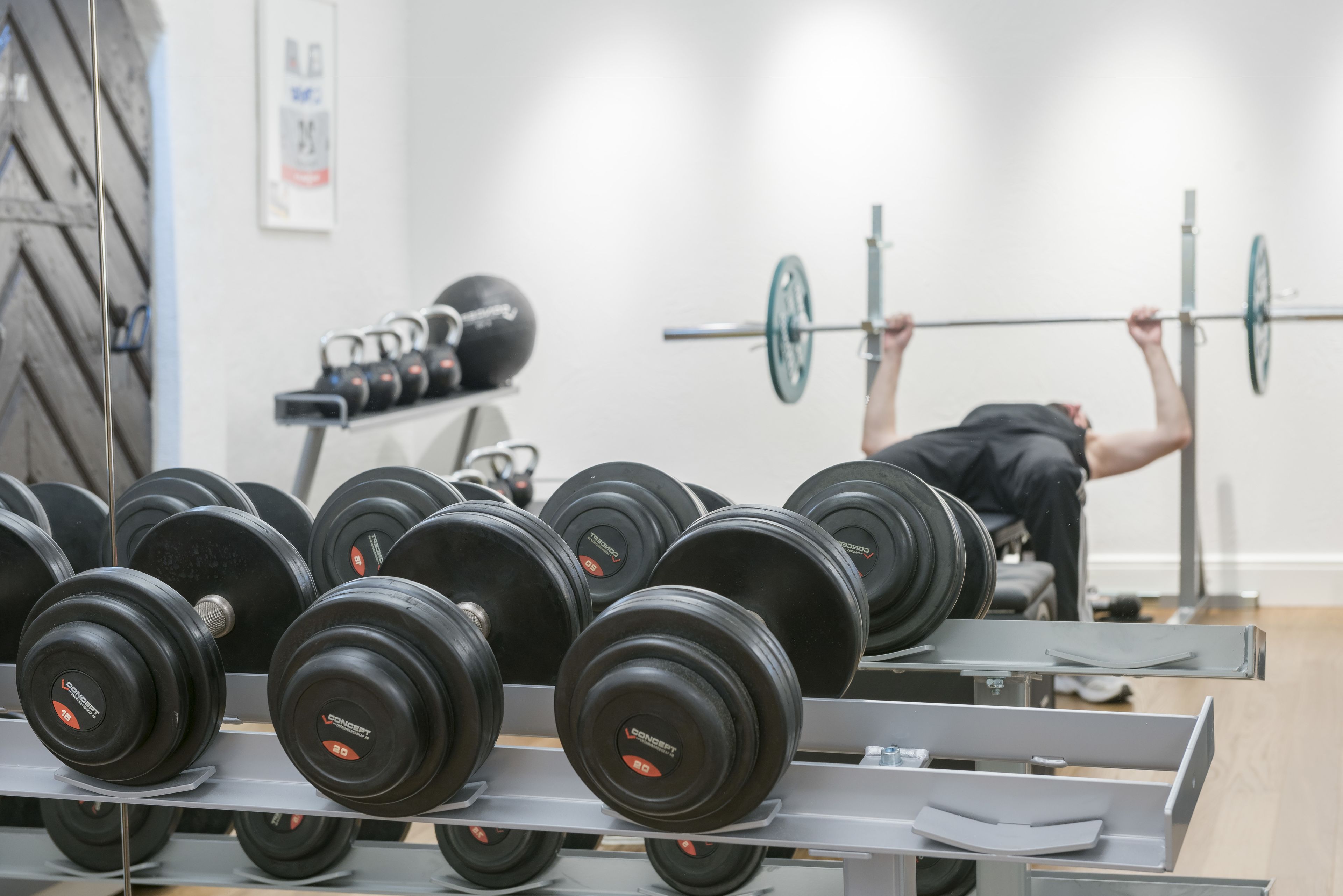 Une salle de sport équipée de matériel de musculation, notamment des barres et des haltères.