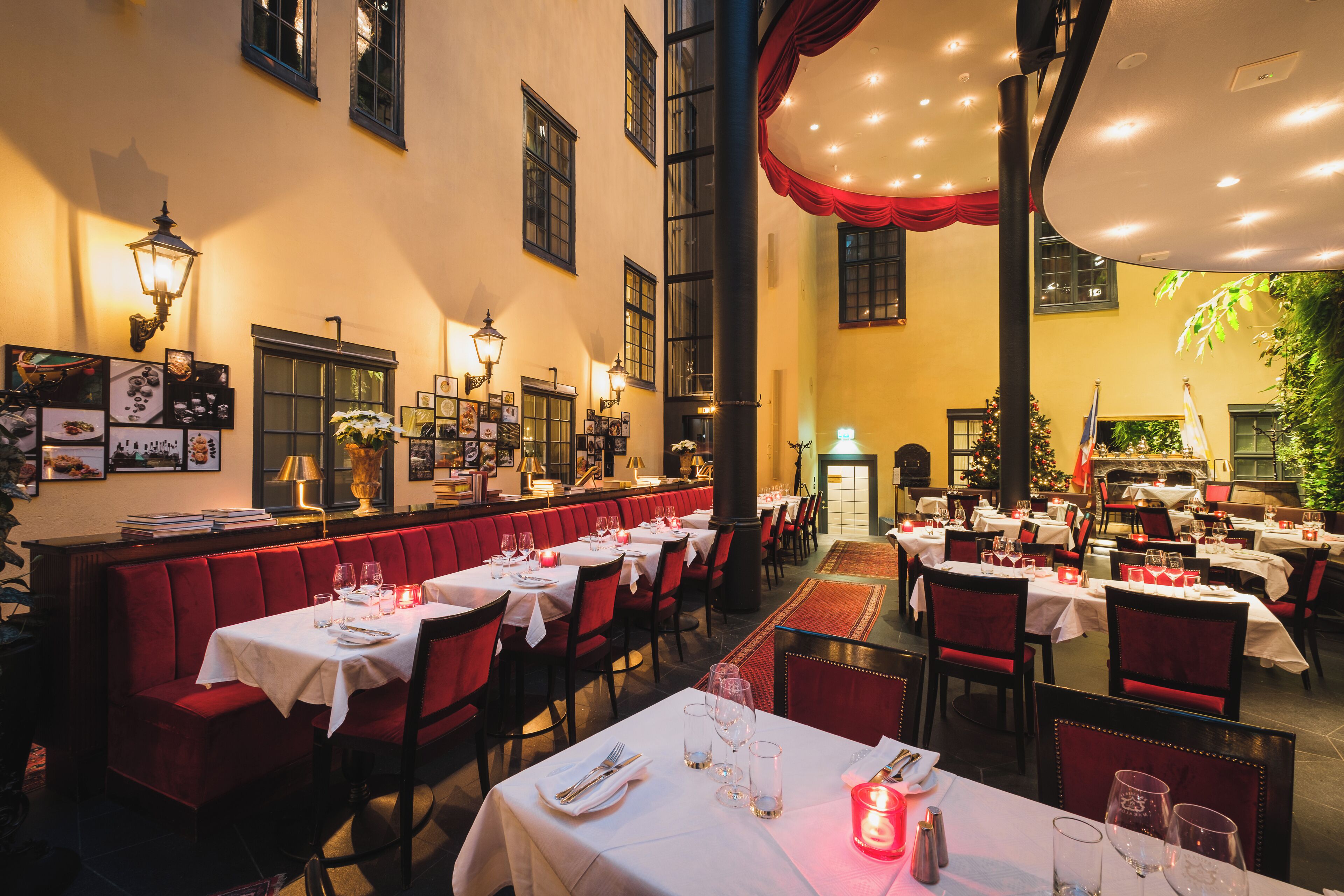 Ein Restaurant mit rot gepolsterten Sitzecken und gedeckten Tischen.