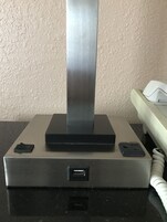 Una mesa metálica con un puerto USB, una regleta y un teléfono.