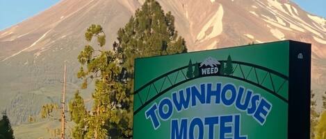 A sign for the Townhouse Motel with a mountain backdrop.