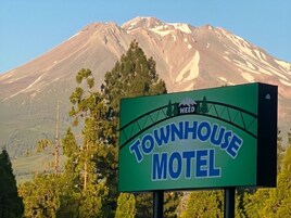 Señal del motel Townhouse con el paisaje de montañas al fondo.