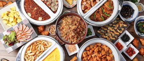 Una variedad de platos y alimentos dispuestos sobre una mesa.