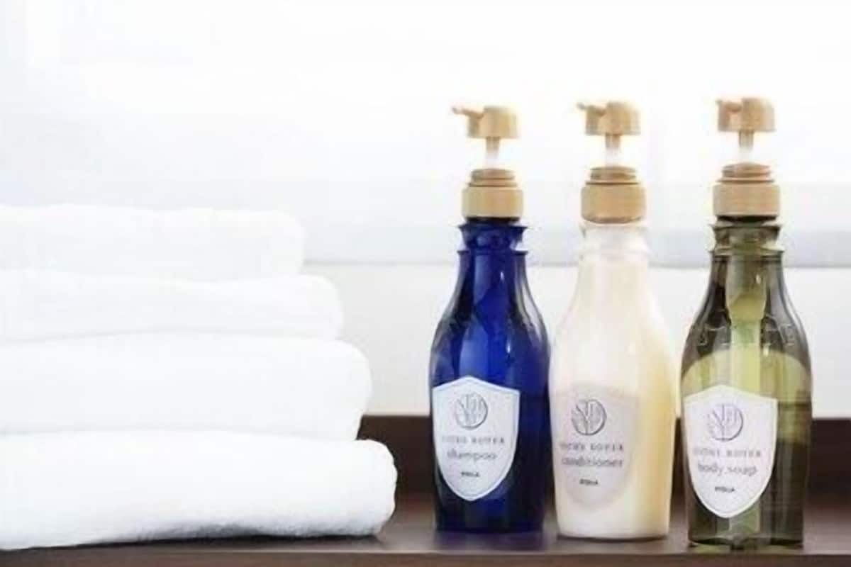 Three bottles of body wash, a white towel, and a wooden surface.