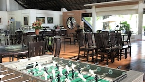 A spacious indoor area with a foosball table, dining tables, and chairs. - Les Hameaux de l'Orient (Ho Chi Minh City)