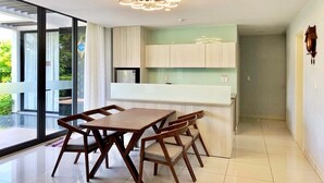 A modern kitchen with a dining area, large windows, and a chandelier. - Viva Villa Oceanami (Nam Nha Trang)