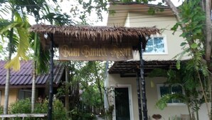 Un edificio con techo de paja y entrada que indica "Bali Bamboo Resort".