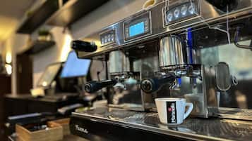 A coffee machine with a digital display and a cup labeled "Maranello" on a counter.