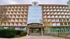 A hotel with a modern glass facade, multiple balconies, and a central entrance with a sign for the Slovnaft Business Center. - Hotel Modena (Bratislava)