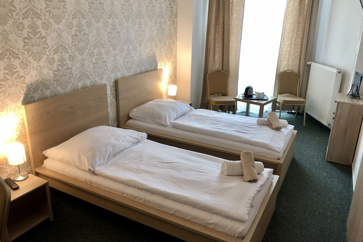 Comfort tvåbäddsrum - 2 enkelsängar | 1 sovrum, värdeförvaringsskåp på rummet och skrivbord