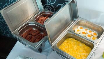 A buffet with various food items including sausages, eggs, and a dish that appears to be scrambled eggs.