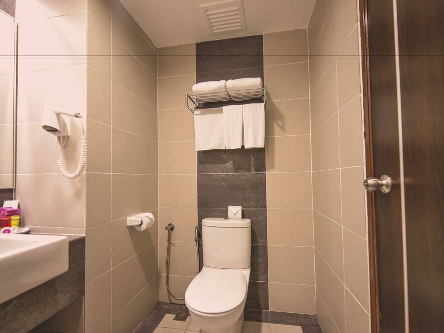 A bathroom with a toilet, a shower, and a sink.