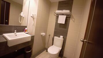 Et badeværelse med vask, toilet og brusebad.