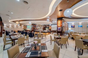 A spacious hotel dining area with multiple tables and chairs, a central bar, and a modern ceiling design. - Adya Hotel Langkawi (Langkawi)