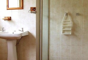 A bathroom with a pedestal sink, a glass shower enclosure, and a towel rack. - Airport Lodge Guest House (Kempton Park)