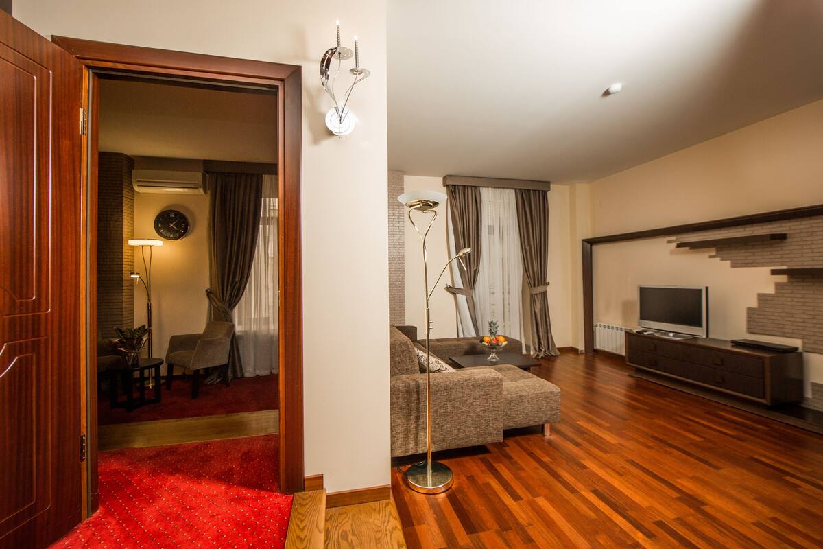 Ein modernes Wohnzimmer mit einer Couch, einem Fernseher und einer Treppe.