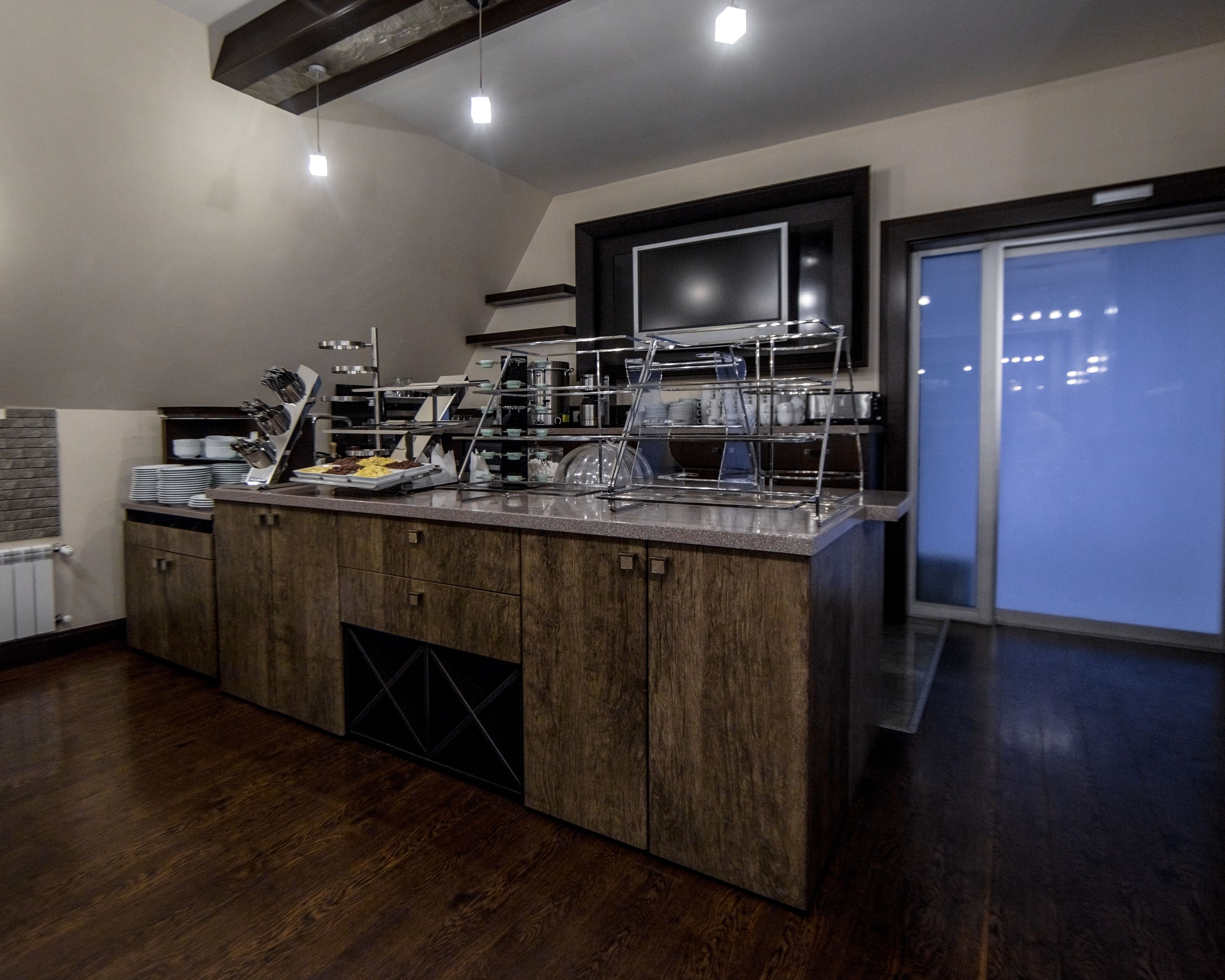 A modern kitchen with a built-in island, stainless steel appliances, and a large window.