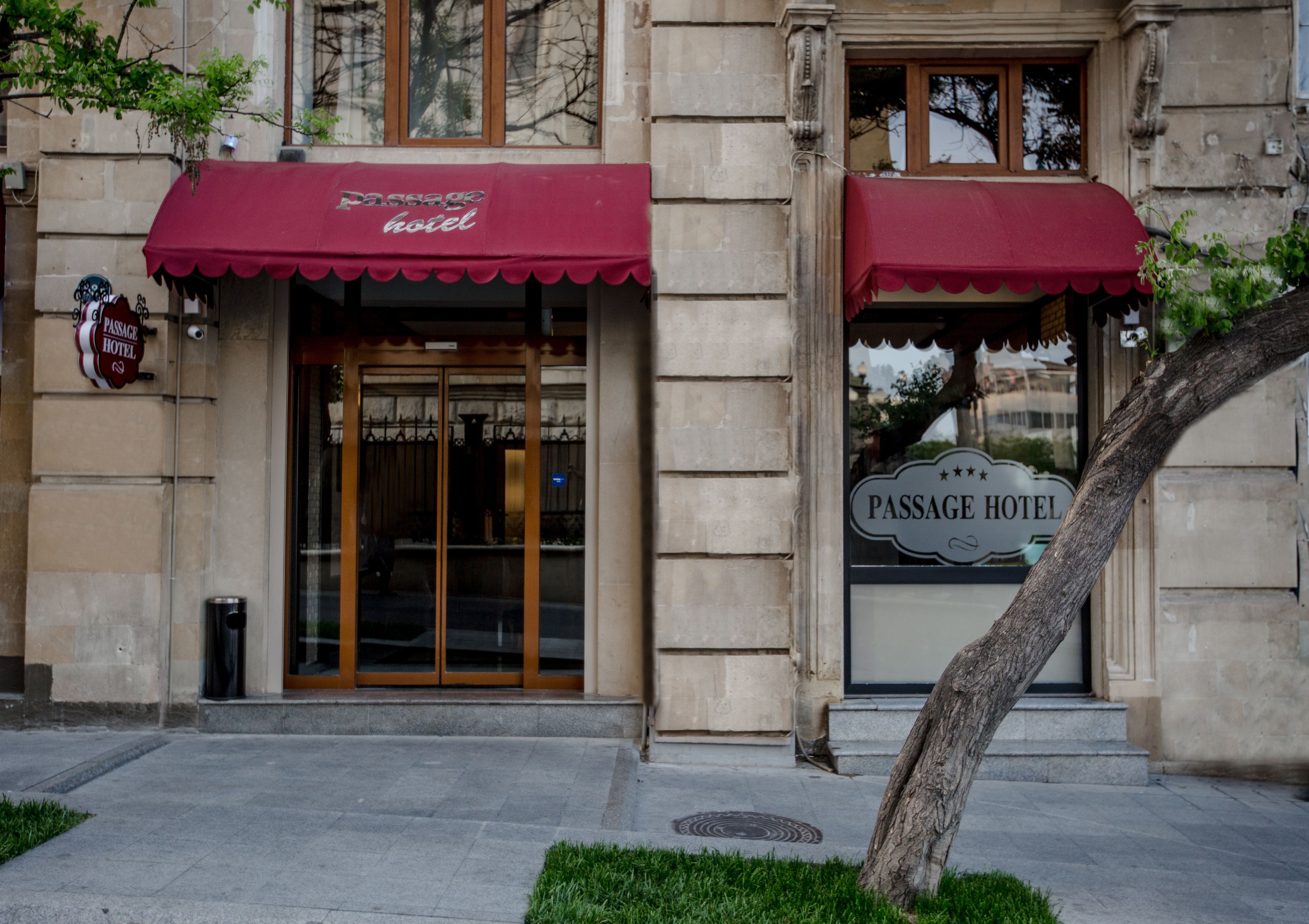 Esterno dell'Hotel Passage con tenda rossa, facciata in pietra e insegna.