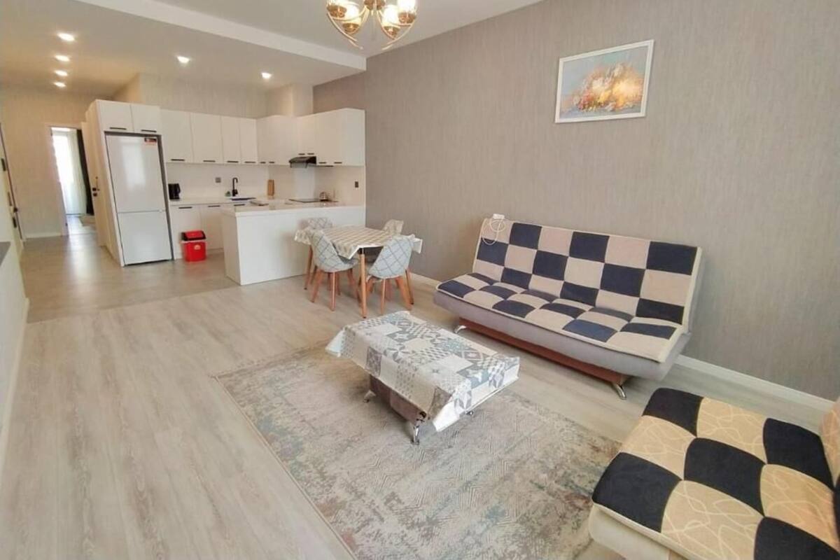 Ein modernes Wohnzimmer mit einer Couch, einem Couchtisch und einem Essbereich mit Stühlen.