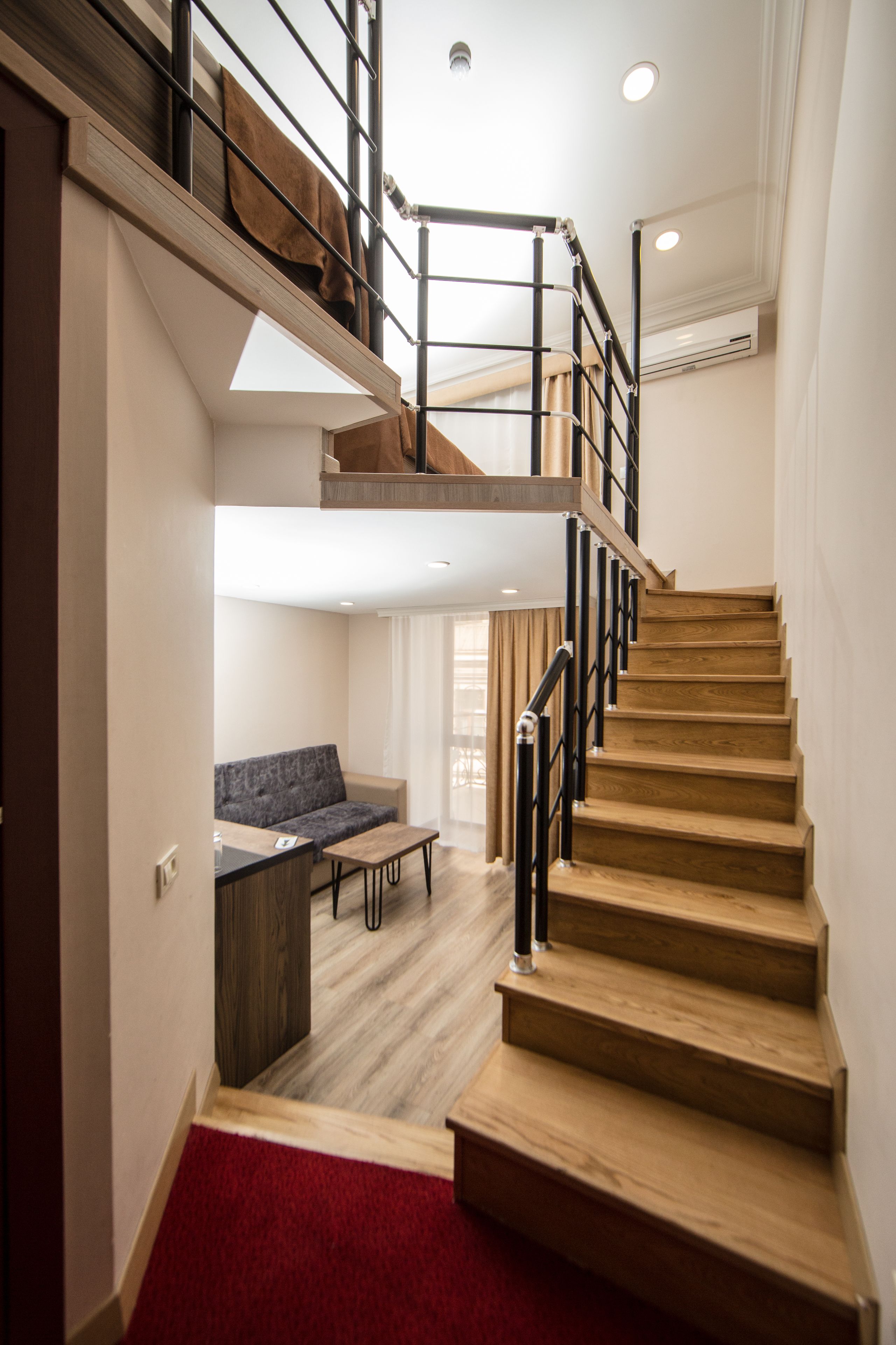 A staircase with wooden steps and metal railings leading to an upper level.