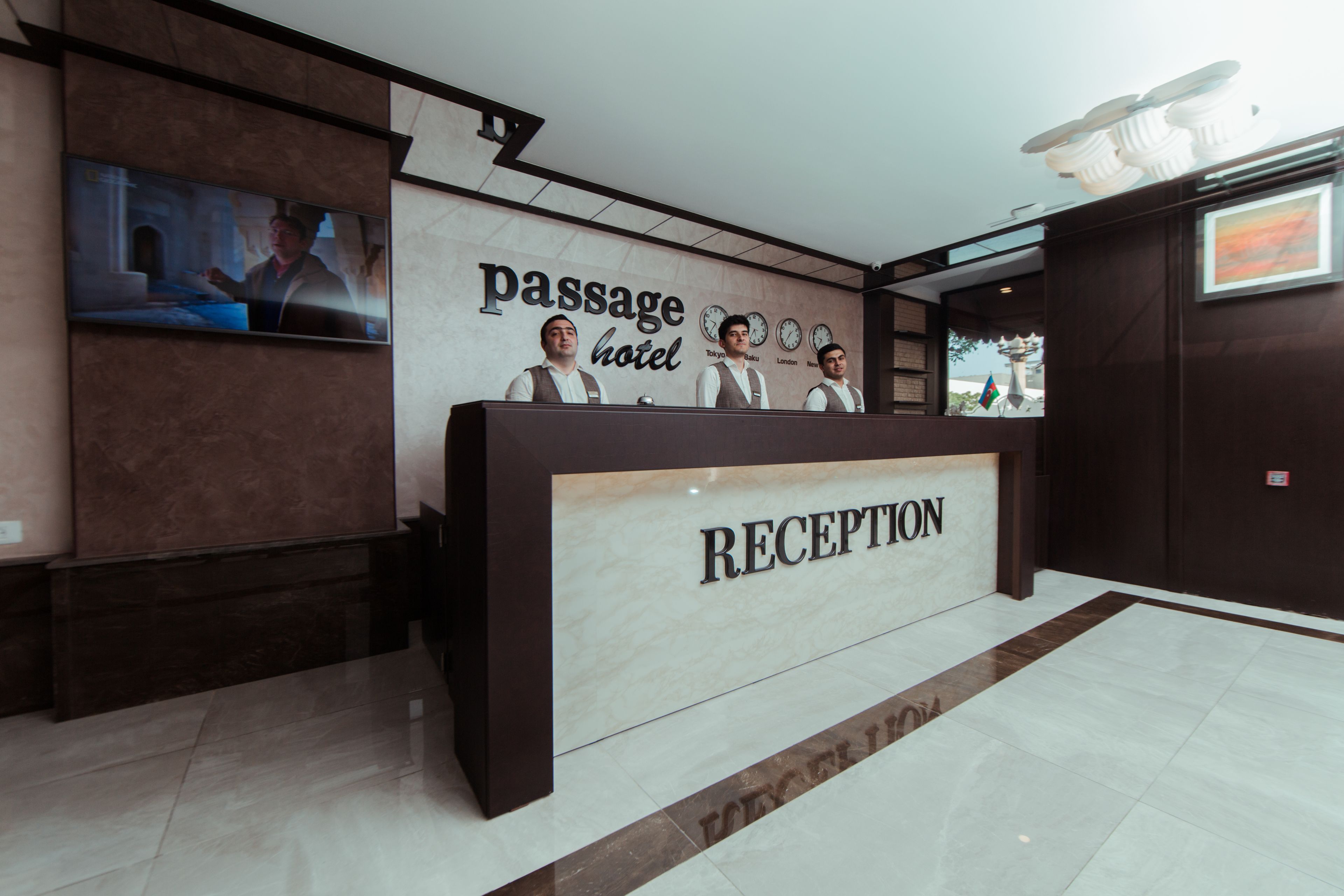 A reception desk with a sign reading "RECEPTION" and "passage hotel" above it.