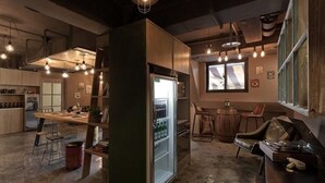 Una cucina moderna con frigorifero, sgabelli da bar e zona pranzo.