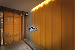 A hallway with a yellow wall and a sign reading "100 hostel". - Ximen WOW Hostel (Taipei)