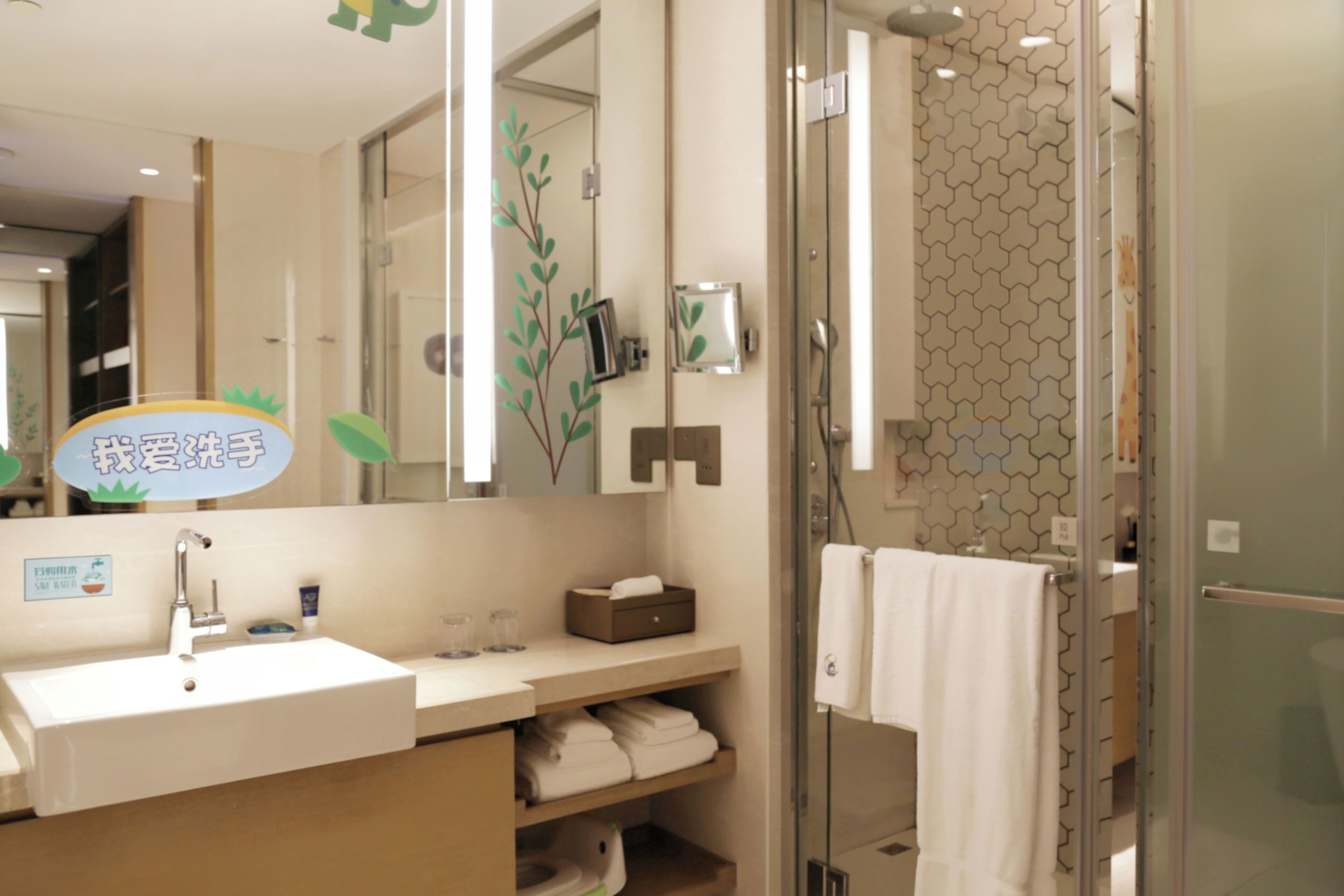 A modern bathroom with a glass shower enclosure, a sink with a mirror, and a towel rack.