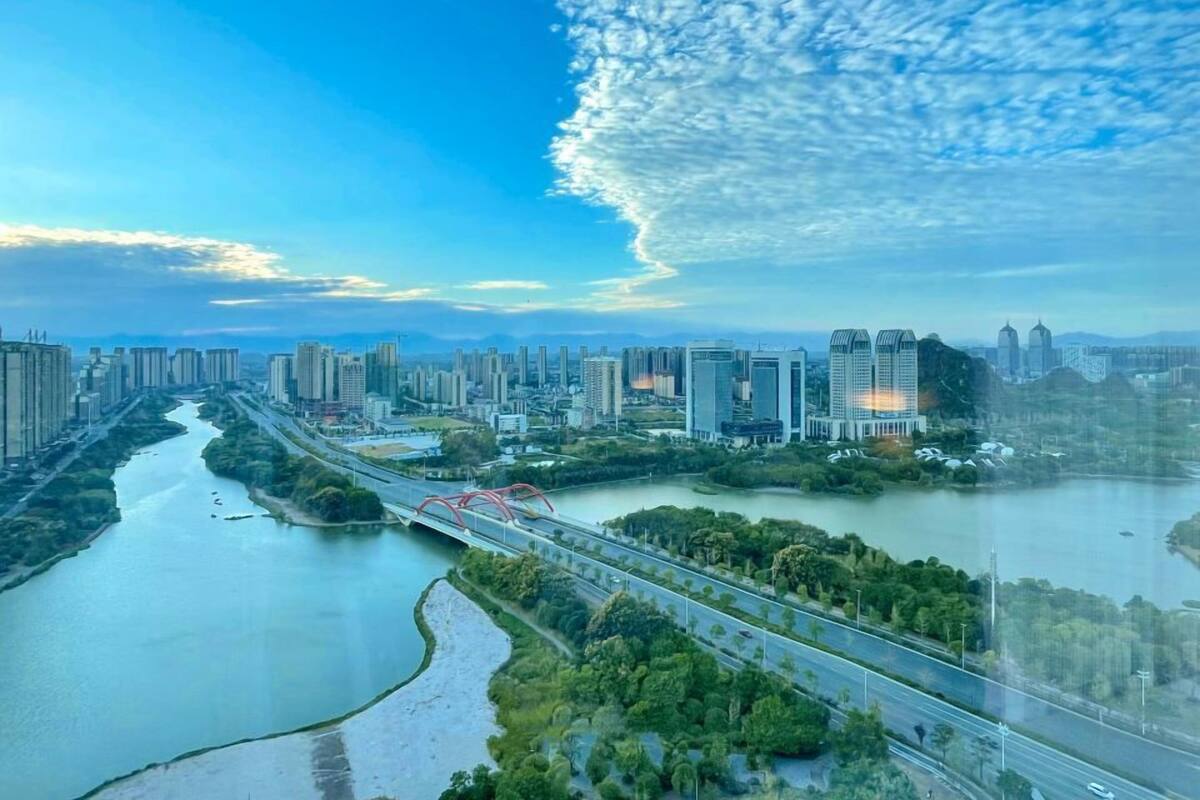 Un paisaje urbano con un río, edificios modernos y un puente.