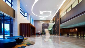 A spacious lobby with a modern design, featuring a central staircase, seating areas, and large windows. - Four Points By Sheraton Guilin, Lingui (Guilin)