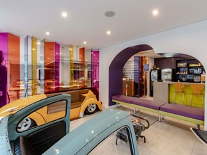 Een modern interieur met een presentatie van oldtimers, een bar en een zithoek.
