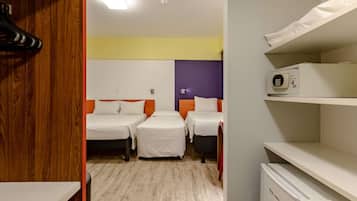 A hotel room with two beds, a microwave, a small refrigerator, and a wooden closet.