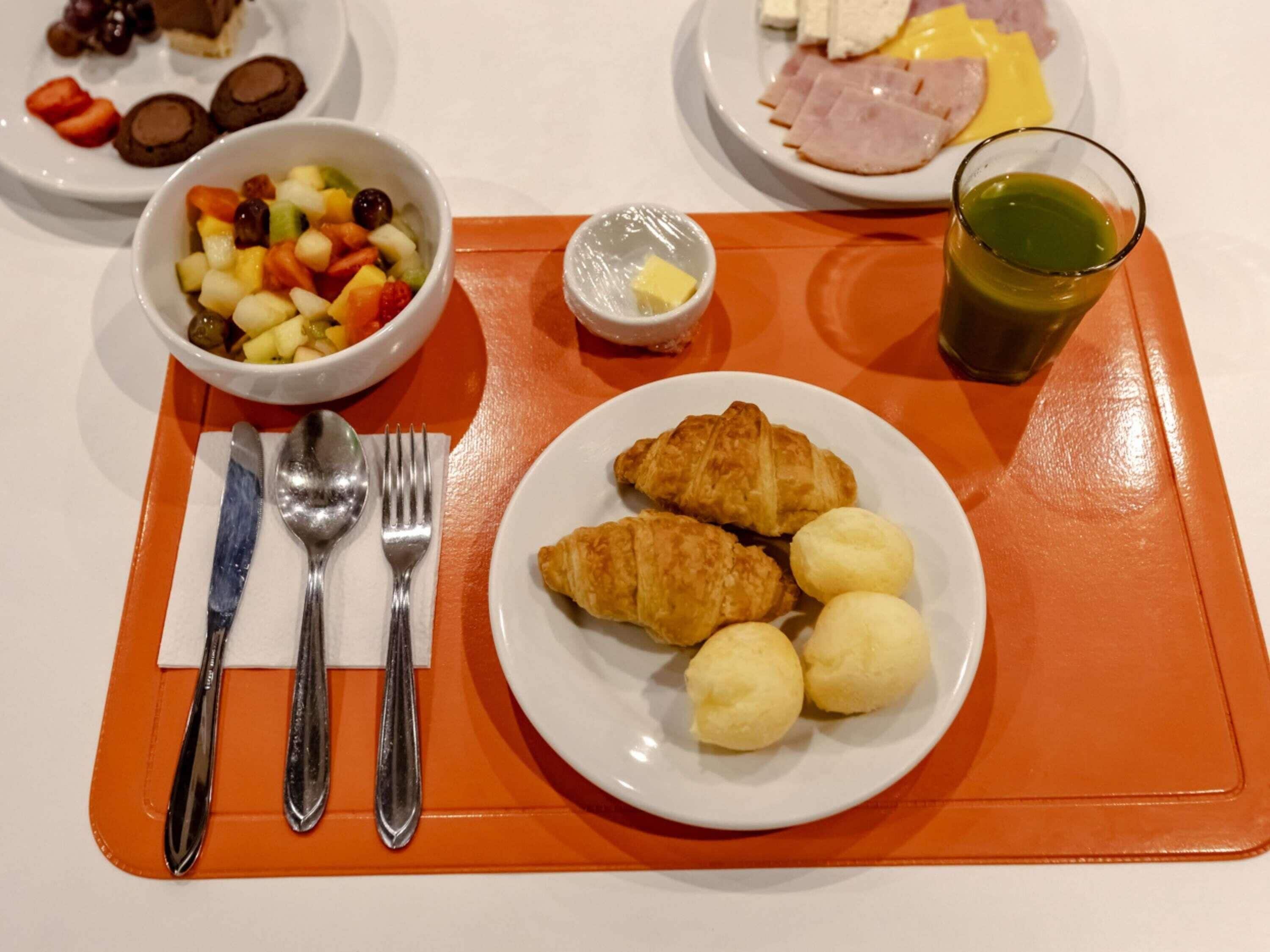 Desayuno con cruasanes, huevos cocidos y un bol de fruta.