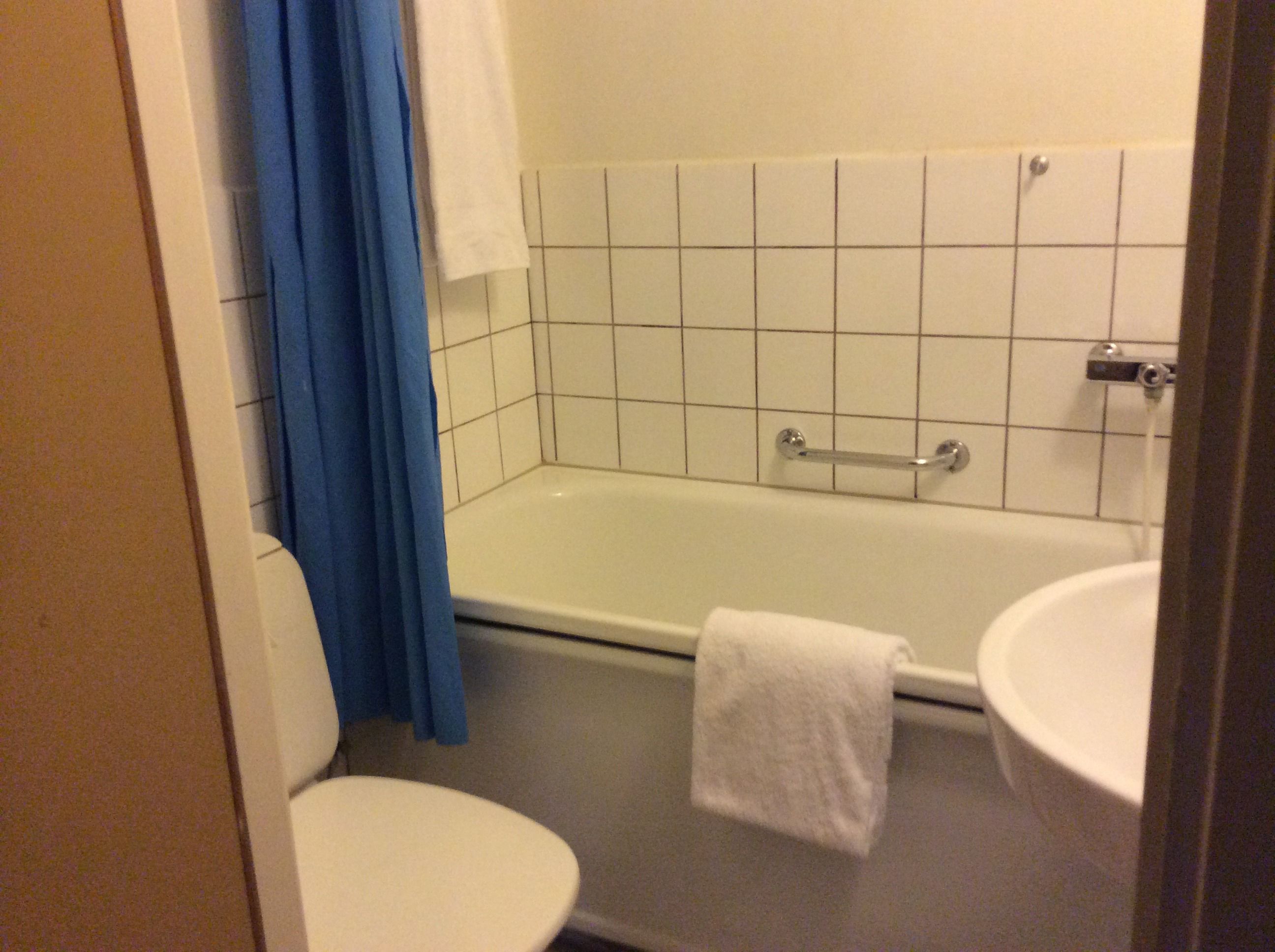 A bathroom with a bathtub, toilet, and sink.