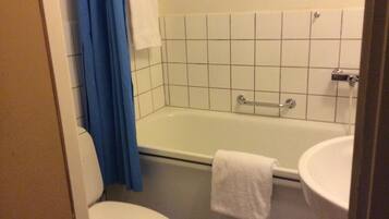 A bathroom with a bathtub, toilet, and sink.